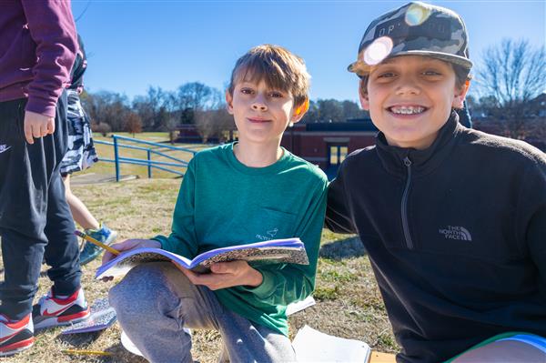 two boys smiling in the grass
